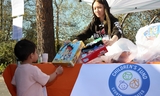 Children's Fund employee hands a toy to a child.